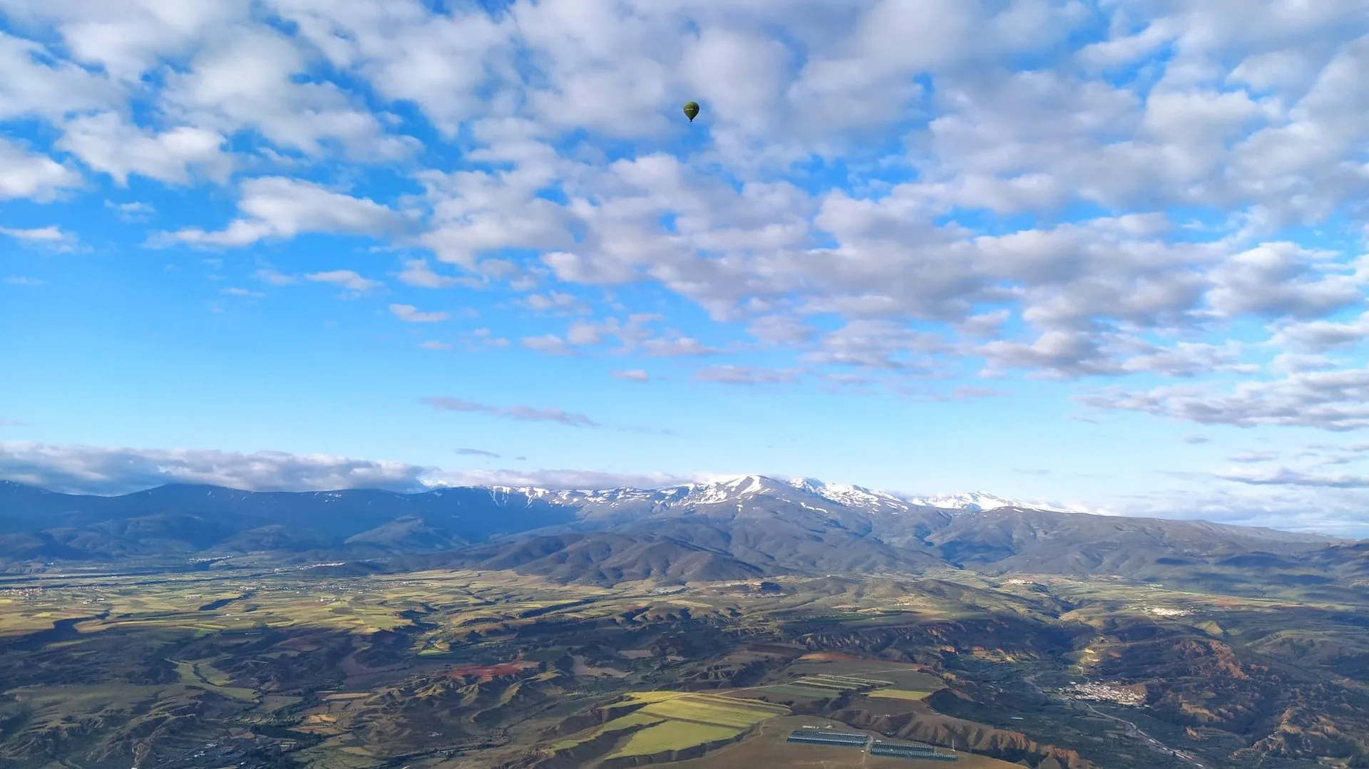 Hot air balloon over Guadix with the Sierra Nevada in the background