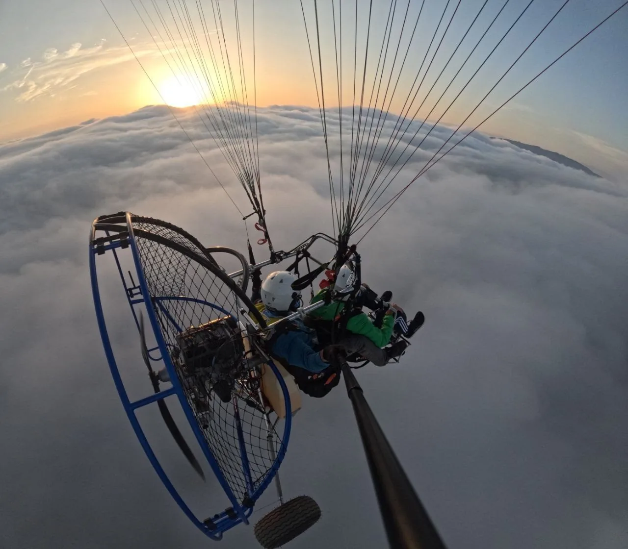 Vuelo en paramotor al atardecer, con el motor y la hélice visibles