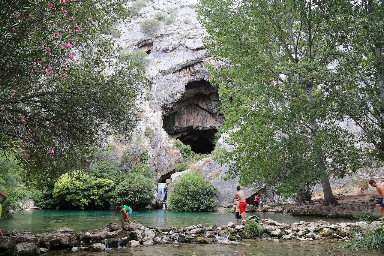 Charco y cascada junto a la boca de la Cueva del Gato, en Benaoján